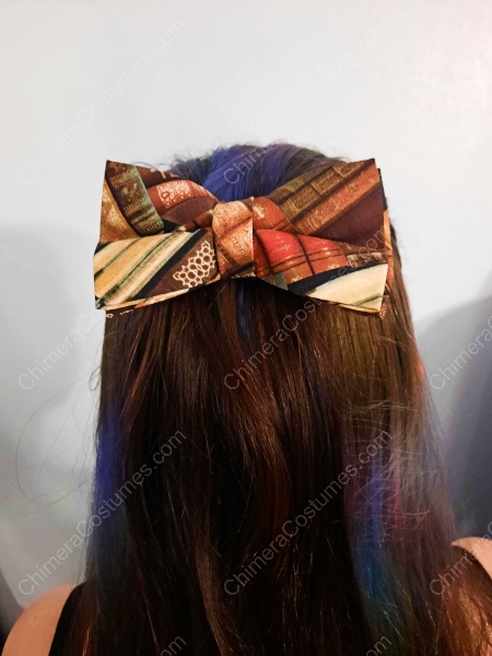 An adorable hair bowtie adorned with miniature replicas of classic library books, embodying a charmingly nerdy aesthetic perfect for bookworms and literary enthusiasts.